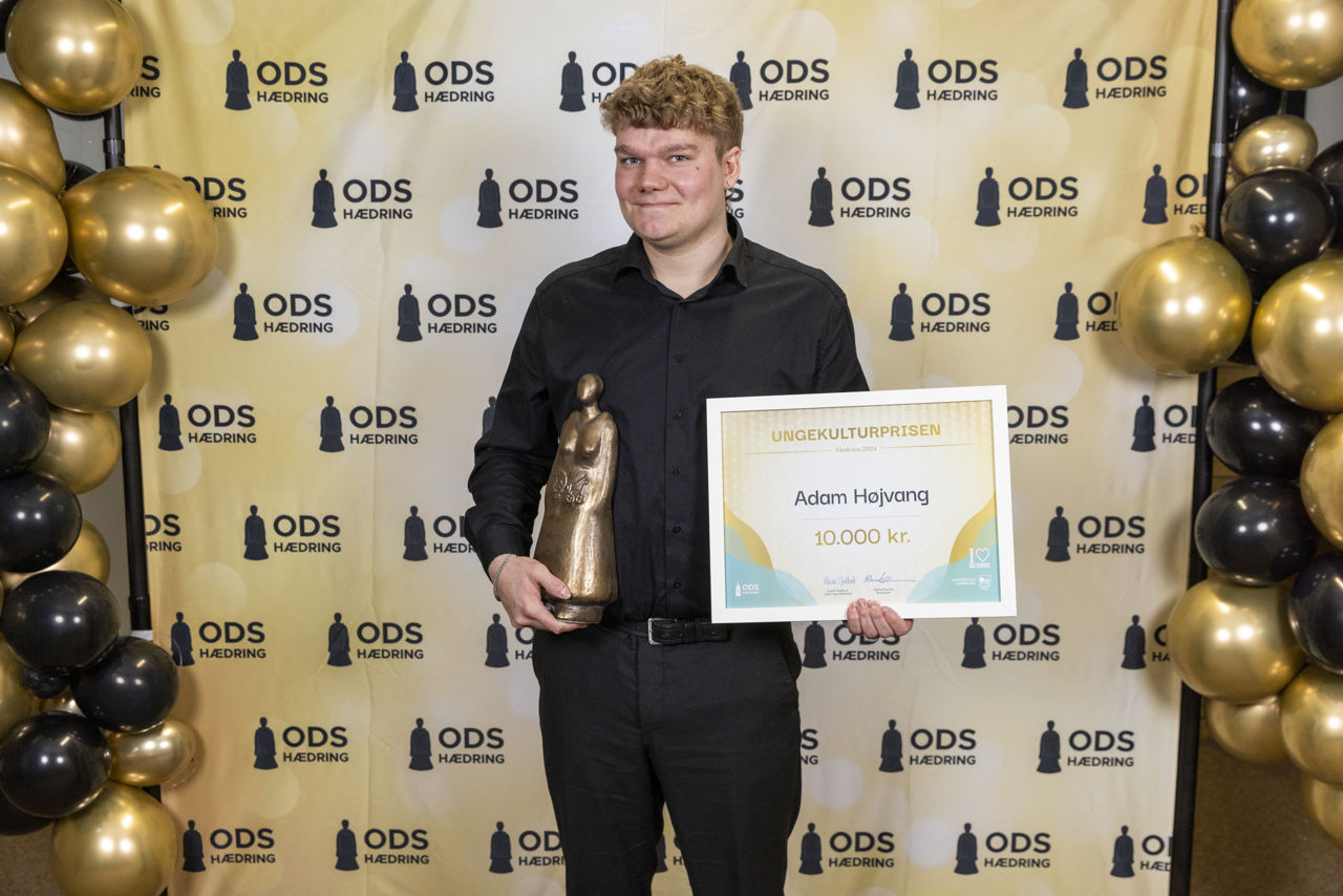 Adam Højvang står med statuette og diplom